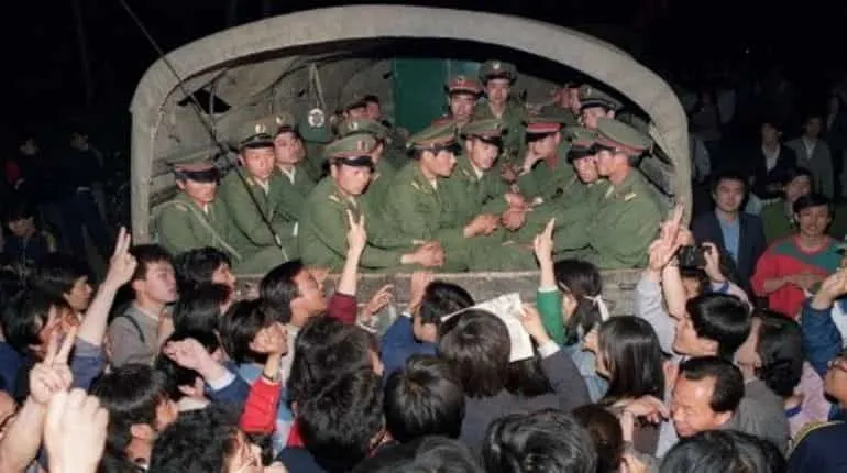 Pro-democracy demonstrators raise their fists and flash Victory signs 20 May 1989 in Beijing as they stop the military truck filled with soldiers on its way to Tiananmen Square 20 May 1989 after the Martial Law was proclaimed in Beijing 20 May.